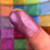 Close up finger swatch on fair skin tone of Baroque Pearlescent Multichrome Eyeshadow