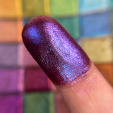 Close up finger swatch on fair skin of Coat of Arms Hybrid Multichrome Eyeshadow