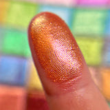 Close up finger swatch on fair skin tone of Court Jester Glitter Vibrant Multichrome Eyeshadow