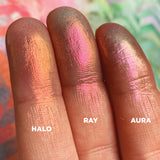 Left angled finger swatches on fair skin tone of Aura Iridescent Multichrome Eyeshadow shifts compared to Halo, Ray