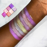 Top angled arm swatches on deep skin tone of Tracery Glitter Multichrome compared to Glazed, Translucency, Sunbeam, Kaleidoscope, Emboss, Spotlight