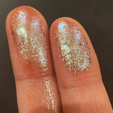 Close up finger swatches on fair skin tone of Grisaille Glitter Multichrome Eyeshadow