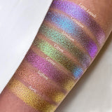 Top angled arm swatches on medium skin tone of Lapis Lazuli Deep Iridescent Multichrome Eyeshadow shifts compared to Cerulean, Virdian, Citron, Cerise, Saffron and Auric