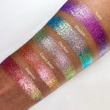 Top angled arm swatches on medium skin tone of Duchess Glitter Vibrant Multichrome Eyeshadow shifts compared to Noble, Diadem, Court Jester and Empress