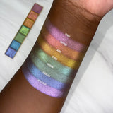 Top angled arm swatches on deep skin tone of Deep Iridescent Multichrome Expansion Bundle (New Shades Only) featuring: Cerise, Saffron, Auric, Citron, Viridian, Cerulean and Lapis Lazuli
