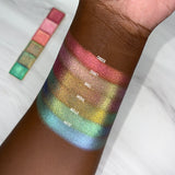 Top angled arm swatches on deep skin tone of Cinder Electric Multichrome Pigment shifts compared to Signet, Oriel, Mural, Niello and Motif
