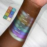 Top angled arm swatches on deep skin tone of Flare Glitter Multichrome eyeshadow shifts compared to Trinket, Embellishment, Flagstone, Ciel, Etched, Glaziers Mark and Adornment