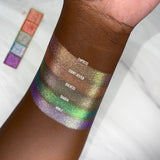 Top angled arm swatches on deep skin tone of Duchess Glitter Vibrant Multichrome Eyeshadow shifts compared to Empress, Court Jester, Diadem and Noble