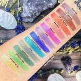 Top angled arm swatches on fair skin tone of Witchcraft vs. Alchemy Collection including Toadstool Duochrome Eyeshadow