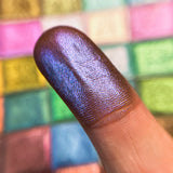 Close up finger swatch on fair skin tone of Lapis Lazuli Deep Iridescent Multichrome Eyeshadow