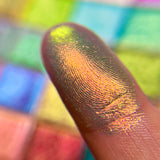Close up finger swatch on fair skin of Mural Electric Multichome eyeshadow