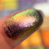 Close up finger swatch on fair skin tone of Solder Dimensional Multichrome Eyeshadow.