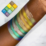 Top angled arm swatches on deep skin tone of Bloodline Vibrant Multichrome Eyeshadow compared to Majesty, Throne, Courtyard, Heirloom, Lineage, Crown Jewel, Royalty
