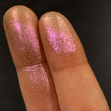 Close up finger swatches on medium skin tone of Engrave Glitter Multichrome Eyeshadow