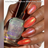 Close up shot of nails done with Walking on Air and Cloud 9 Nail Lacquers over an orange base on medium skin tone.