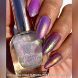 Close up shot of nails done with Cloud 9 and Simply Beaming Nail Lacquers over a purple base on medium skin tone.