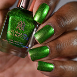 Close up shot of Appletini Nail Lacquer as applied to darker skin tone with nail lacquer bottle