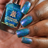Close-up shot of Blue Hawaiian nail lacquer applied to finger nails on a darker skin tone, with nail lacquer bottle in hand
