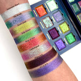 Arm swatches on fair skin tone of all 8 shadows included in the Deep Sea Treasures Palette with the Palette in the background. Top to bottom: Saltwater Pearl, The Bends, Fool's Gold, Kelp Forest, Ring of Fire, Cephalopod, Shipwreck and S.C.U.B.A.