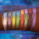 Arm swatches on deep skin tone of all 8 shadows included in the Deep Sea Treasures Palette. Left to right: Saltwater Pearl, The Bends, Fool's Gold, Kelp Forest, Ring of Fire, Cephalopod, Shipwreck and S.C.U.B.A.