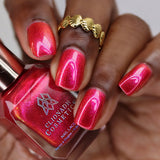 Close-up of nails painted with La Vie En Rose Nail Lacquer on deep skin tone. Hand is holding polish bottle.