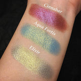 Top angled arm swatches on fair skin tone of Aqua Fortis compared to Cinnabar, Elixir