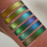 Left angled arm swatches on medium skin tone of Trefoil Jewelled Multichrome Eyeshadow shifts compared to Gargoyle, Castle, Anneal, Patina, Weathered