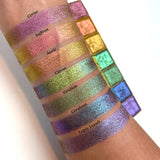 Top angled arm swatches on fair skin tone of Saffron Deep Iridescent Multichrome Eyeshadow shifts compared to Cerise, Auric, Citron, Viridian, Cerulean and Lapis Lazuli