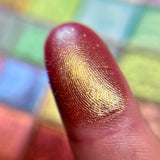 Close up finger swatch on fair skin of Bronze Fountain Earth Vibrant Mulitchrome Eyeshadow