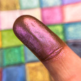 Close up finger swatch of Cerise Deep Iridescent Multichrome Eyeshadow on fair skin