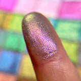 Close up finger swatch on fair skin tone of Cobblestone Earth Vibrant Multichrome Eyeshadow