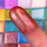 Close up finger swatch on fair skin tone of Coronation Vibrant Multichrome Eyeshadow