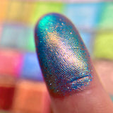 Close up finger swatch on fair skin tone of Diadem Glitter Vibrant Multichrome Eyeshadow