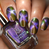 Close up of nails done with Distortion nail lacquer featuring an X shaped magnetic effect on medium skin tone.