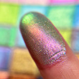Close up finger swatch on fair skin tone of Emblem Electric Multichrome Eyeshadow