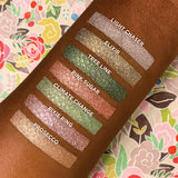 Top angled arm swatches on deep skin tone of Elixir compared to Light Chaser, Tree Line, Pink Sugar, Climate Change, Pixie Ring and Prosecco