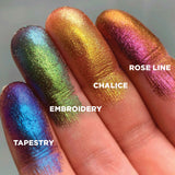 Finger swatches on fair skin tone of Tapestry Hybrid Multichrome Eyeshadow shifts next to Embroidery, Chalice, Rose Line