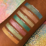 Top angled arm swatches on deep skin tone of Dahlia compared to Aqua Fortis, Sol, Alpine, Honeycrisp, Eye of Newt and Molten