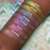 Top angled arm swatches on deep skin tone of Gilding Glitter-Type Iridescent Multichrome Eyeshadow compared to Gloaming, Gleam, Glisten, Glimmer, Glow, Glint