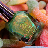 Grow Nail Lacquer bottle on top of sour gummy worms.