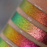 Close up arm swatches on medium skin tone of Forge Jewelled Multichrome Eyeshadow compared to Sand Blast, Kiln