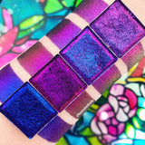 Top angled Gothic Jewelled Multichrome Eyeshadow overtop arm swatches on fair skin tone compared to Flame-Blown, Rosette, Spire