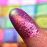 Close up finger swatch on fair skin tone of Rayonnant Electric Multichrome Eyeshadow