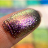 Close up finger swatch on fair skin tone of Redox Dimensional Multichrome Eyeshadow