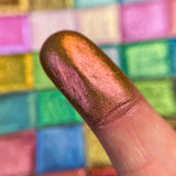 Close up finger swatch on fair skin of Saffron Deep Iridescent Multichrome Eyeshadow
