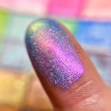 Close up finger swatch on fair skin tone of Tessera Electric Multichrome Eyeshadow