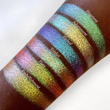 Top angled arm swatches on deep skin tone of Embellishmet Glitter Multichrome Eyeshadow shifts compared to Flagstone, Adornment, Etched, Trinket and Flare