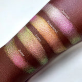 Top angled arm swatches on deep skin tone of Baroque Pearlescent Multichrome Eyeshadow shifts comprared to Renaissance, Sceptre  and Palace