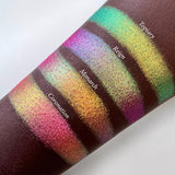 Top angled arm swatches on deep skin tone of Reign Vibrant Multichrome Eyeshadow shifts compared to Topiary, Monarch and Coronation
