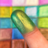 Close up finger swatch on fair skin tone of Topiary Vibrant Multichrome Eyeshadow